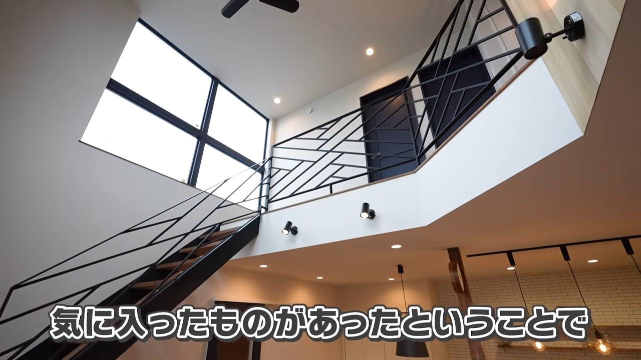 吹き抜けを彩る木のアクセントとアイアン階段